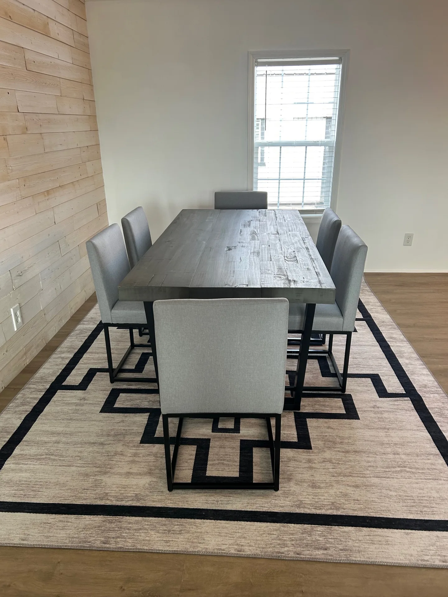 Dining from wider angle with accent wall, parsons chairs, and Greek-key rug