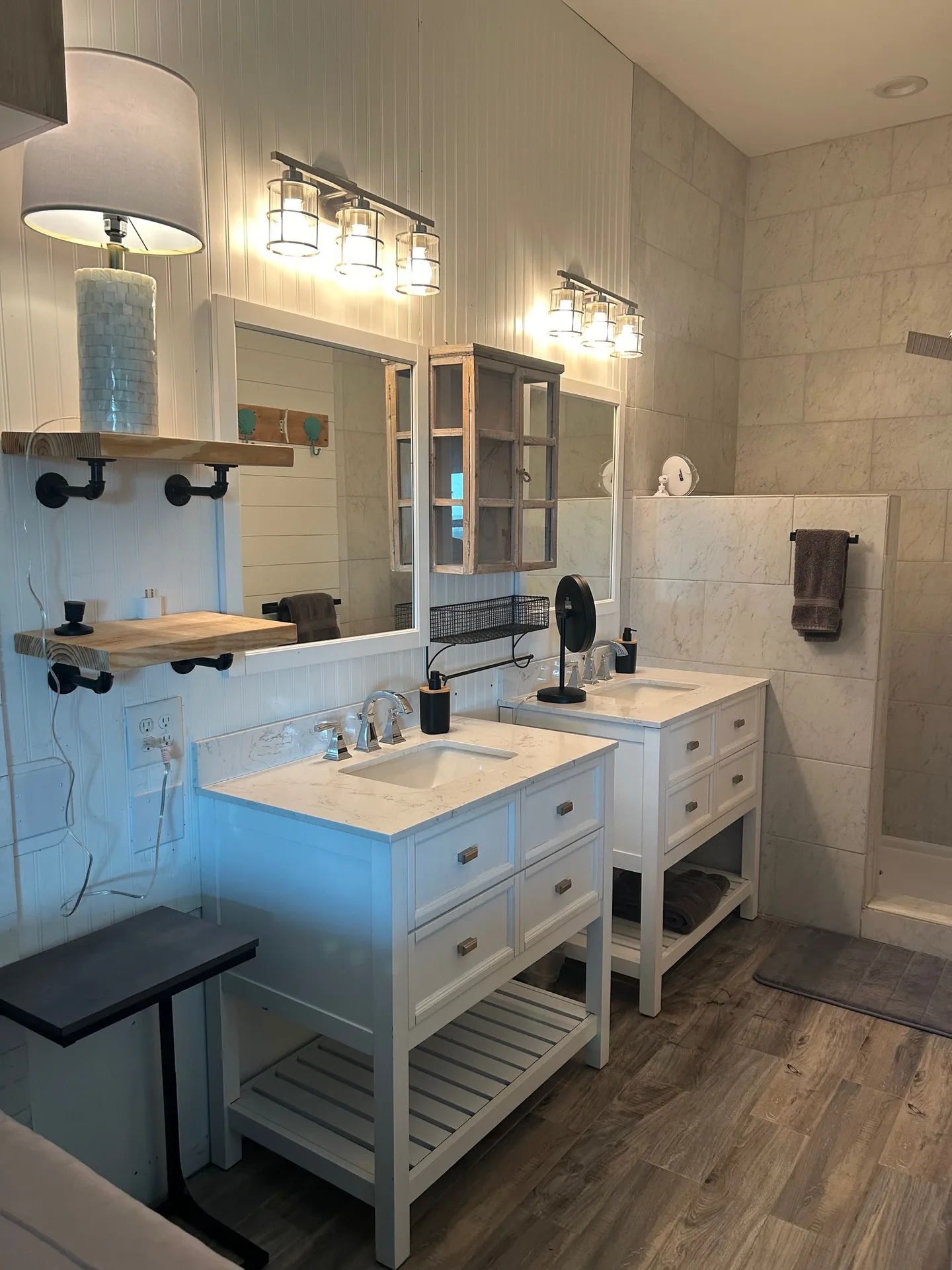 Double vanity bathroom with two Shaker vanities, marble tops, and shower tile