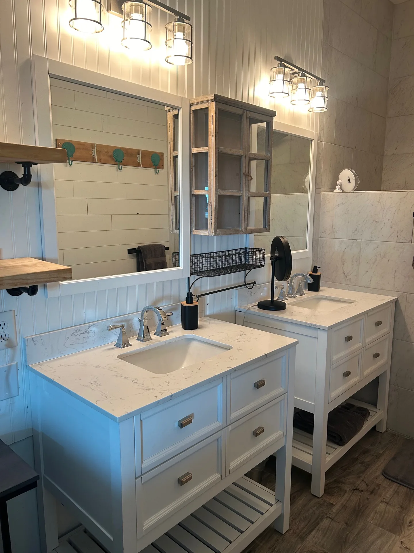 Master bath vanity with marble tops, glass-paned medicine cabinet, and turquoise hooks