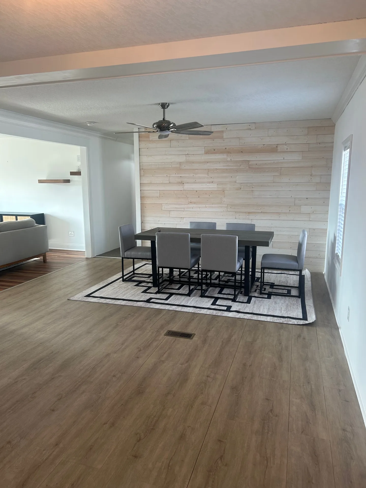 Dining table close-up with reclaimed wood surface and blonde wood plank accent wall